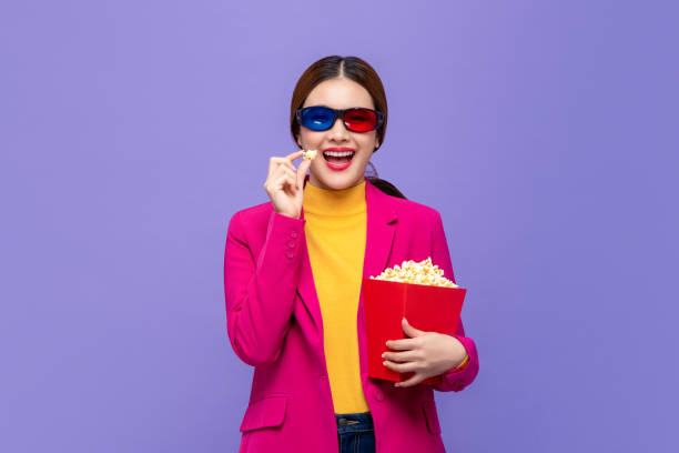 junge asiatische frau trägt 3d-brille genießen popcorn essen und film ansehen - anaglyph stock-fotos und bilder