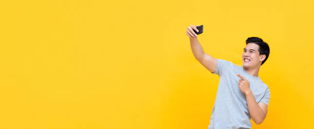 istock Young smiling handsome Asian man taking selfie with smartphone 1191320074