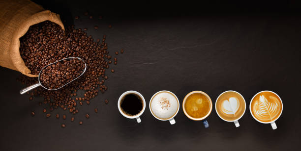 varietà di tazze di caffè e chicchi di caffè in sacco di tela su sfondo nero - coffee foto e immagini stock