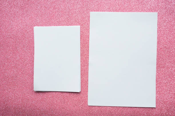 dos bofeteas de papel en blanco sobre fondo de brillo rosa - paper sheet fotografías e imágenes de stock