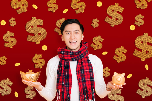asian young man showing the gold piggy bank celebrating for chinese new year.