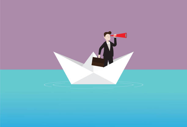 istock Businessman with a telescope on a paper boat 1191329136