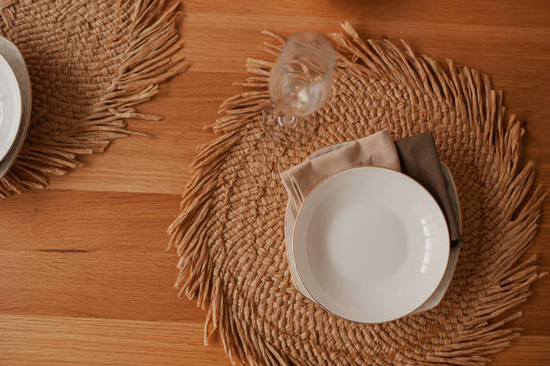 istock eco-friendly table setting in minimalism, a white deep plate on a natural round napkin made of hay, with cotton napkins, on a wooden table top view 1191339717