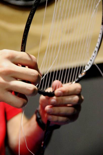 regula a tensão da corda da raquete do badminton, vertical. jovem conserta uma raquete de badminton. sem pessoas - racket string - fotografias e filmes do acervo