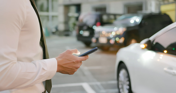 asian businessman unlock door of car by using smart phone
