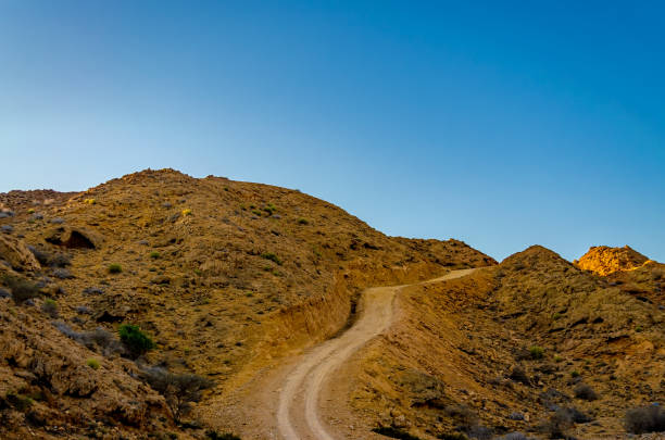 istock Dirt Road through Barren Mountains 1191353123