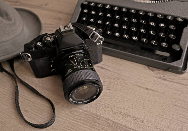 istock A vintage camera beside a typewriter and fedora 1191360855