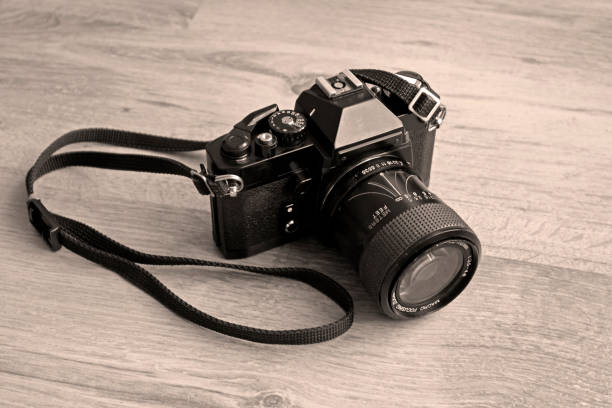 istock A vintage 35mm camera resting on a wooden surface - Sepia Toned 1191360856