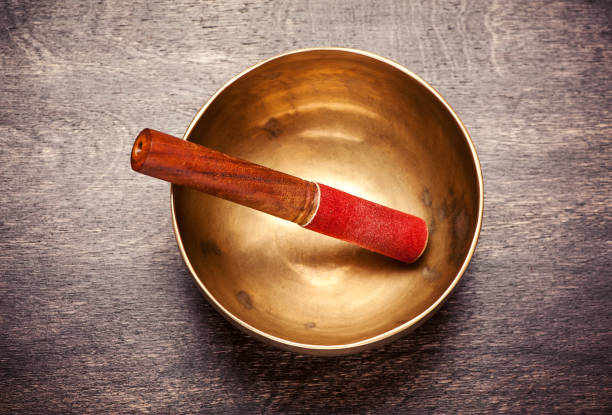 Singing bowl on a wooden background, top view