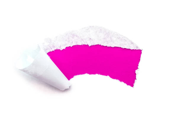 a hole in white paper with torn edges isolated on a white background with a bright pink color paper background inside. - note rose image saturated color imagens e fotografias de stock