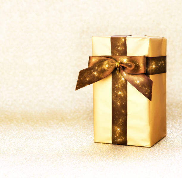istock Golden box with ribbon on a gold background 1191369964