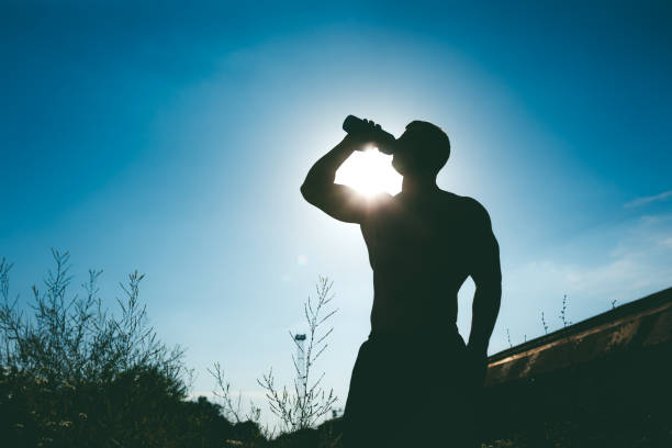 istock Silhouette of muscular man drinking water 1191373924