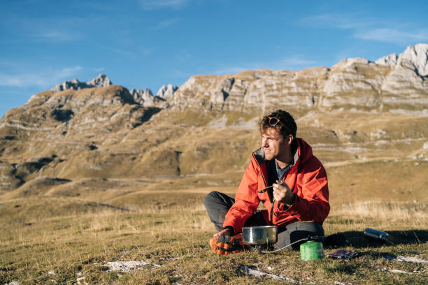 istock Backpacker prepares meal on camp stove in mountains 1191375306