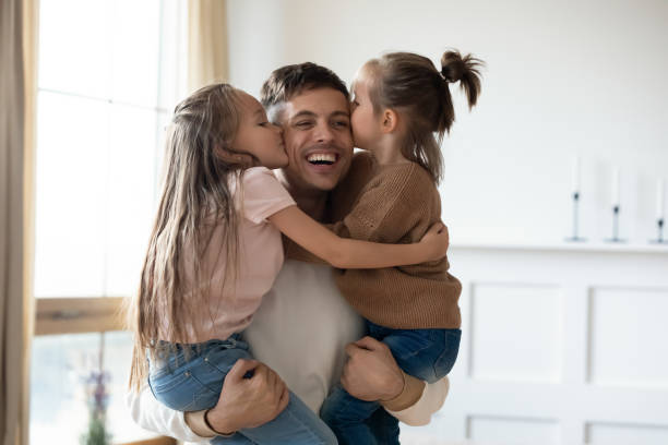 istock Funny cute small daughters kiss happy daddy on cheeks 1191377529