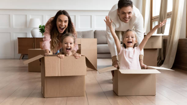 istock Excited family having fun on moving day riding in boxes 1191377937