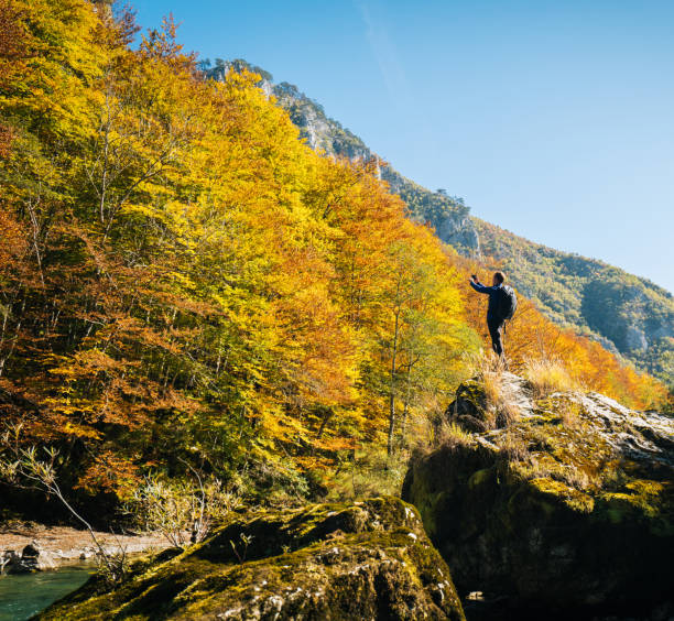istock Hiker relaxes near autumnal river 1191379415