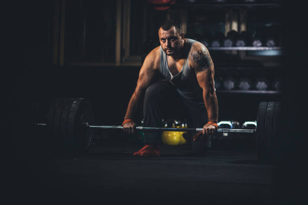 istock Man body builder exercising in dark gym 1191379600
