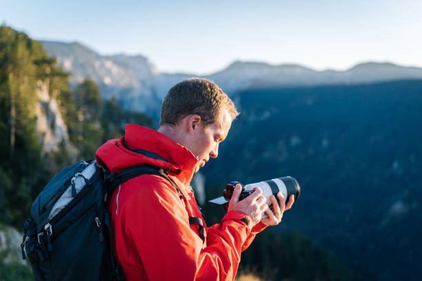 Hiker photographs mountain valley at sunrise
