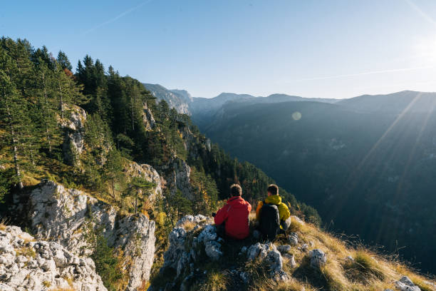istock Hikers relax above mountain valley at sunrise 1191380542