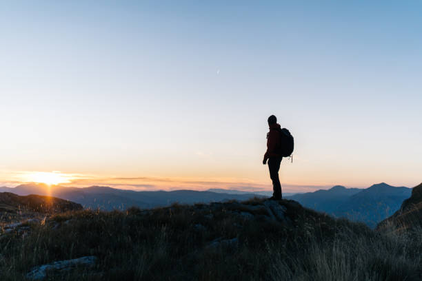 istock Hiker relaxes above mountain valley at sunrise 1191381022