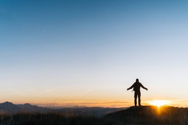 istock Hiker relaxes above mountain valley at sunrise 1191381094