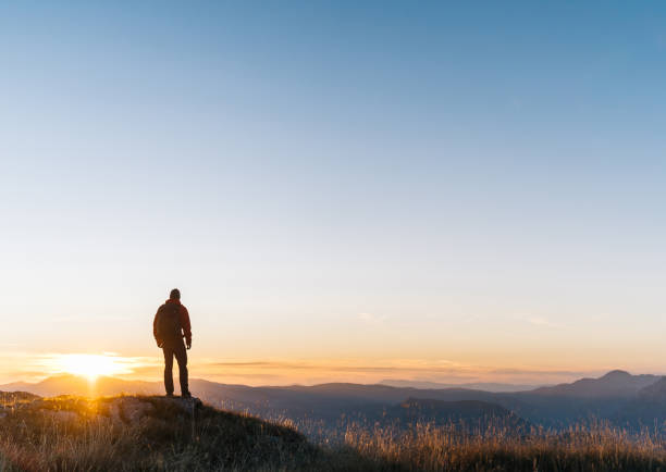 el excursionista se relaja sobre el valle de la montaña al amanecer - solitude mountain range ridge mountain peak fotografías e imágenes de stock