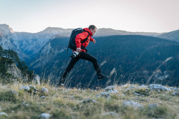 istock Young man runs along mountain ridge at sunrise 1191381345