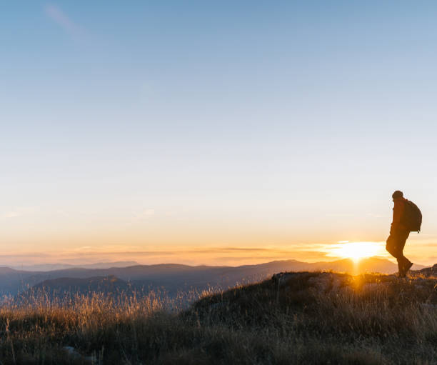 istock Hiker relaxes above mountain valley at sunrise 1191381365