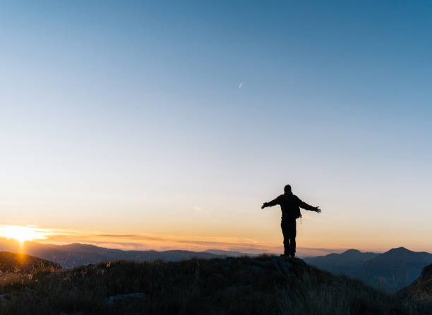 istock Hiker relaxes above mountain valley at sunrise 1191381446