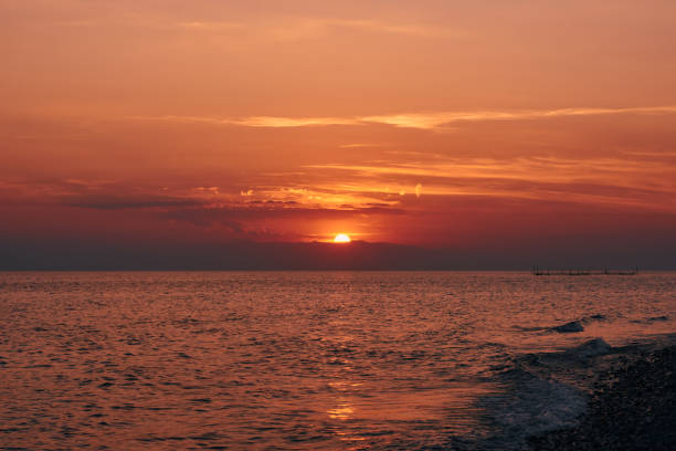 istock Big Orange Sun Setting Over Calm Sea And Mountains In Greece 1191382261