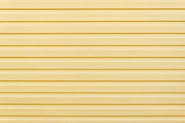 istock Yellow vinyl siding wall surface with horizontal lines 1191386467