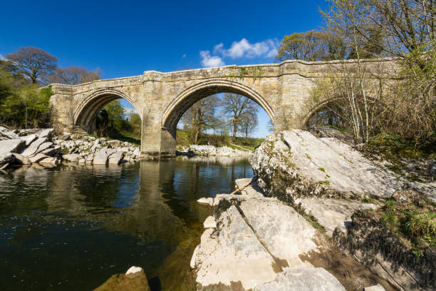 Cтоковое фото Красивый старый каменный арочный мост через реку.