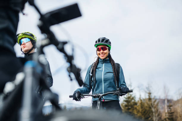 istock Group of mountain bikers standing on road outdoors in winter, talking. 1191389775