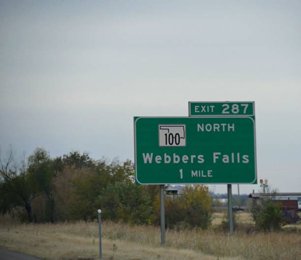 オクラホマ州のウェバーズフォールズへの道順と距離を持つ高速道路沿いの道路沿いの標識。 - oklahoma sign road sign sky ストックフォトと画像