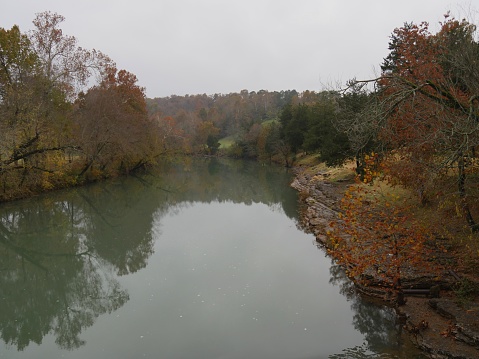 Medium wide shot of the War Eagle River with colorful trees along the banks in autumn
