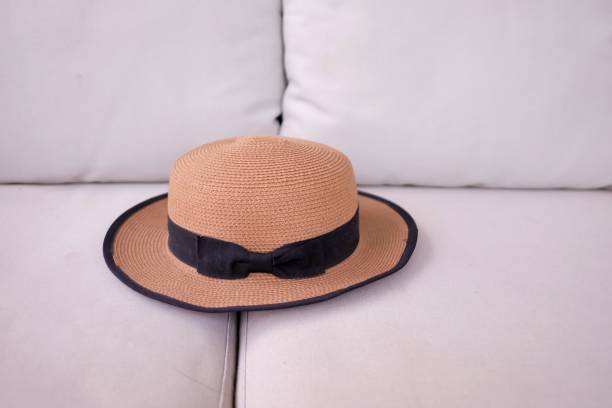 istock Close up a brown straw hat on a grey cough with copy space 1191392382