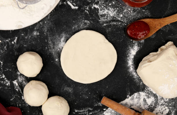 istock prepare dough, pizza with rolling pin on balck background 1191394037