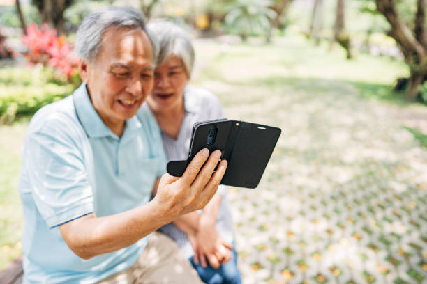 istock Senior couple using mobile phone in park 1191394214