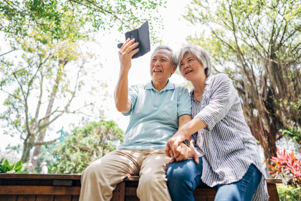 istock Senior couple using smart phone in park 1191394250