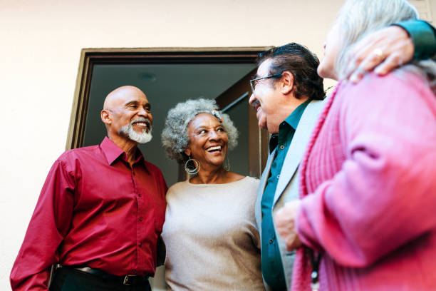 istock Smiling senior friends talking at doorway 1191395227