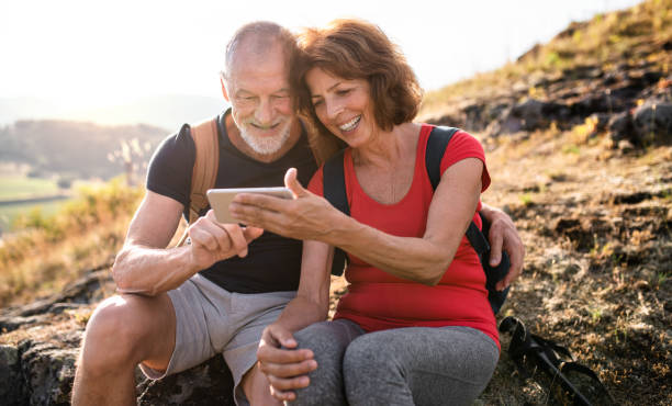 Senior tourist couple hikers in nature, taking selfie. A senior tourist couple hikers in nature, taking selfie. active seniors summer stock pictures, royalty-free photos & images