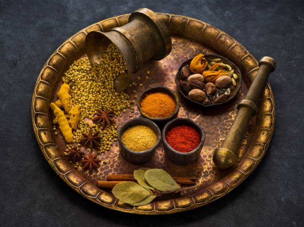 selection of indian spices and seasonings on a metal tray, top view - cardamom cinnamon mortar and pestle herb imagens e fotografias de stock