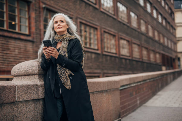 istock Mature lady using mobile in city 1191400133