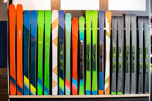 Ski shop sale. Rows of colourful skis on wall.