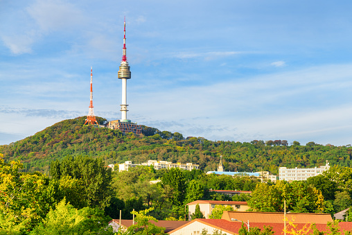 Scenic view of Namsan Seoul Tower on Namsan Mountain in Seoul, South Korea. The tower is a popular tourist attraction of Asia. Awesome sunny cityscape.