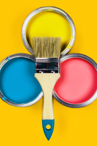 istock Colored background with paint jars and brush. 1191402270