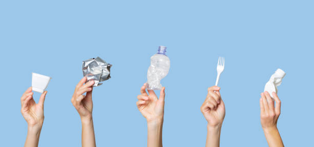 istock Hands holding trash on a light blue background. The concept of separate trash, stop plastic, recycling 1191402721