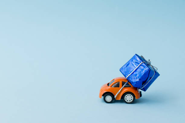 istock car with gift box on blue background, copy space. greeting card 1191404125