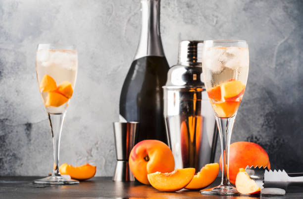Bellini, alcoholic cocktail with sparkling wine, sugar syrup, lemon juice, peach and ice, gray table background, copy space