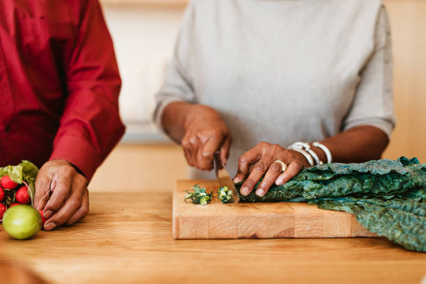 Woman chopping chard on cutting board by husband